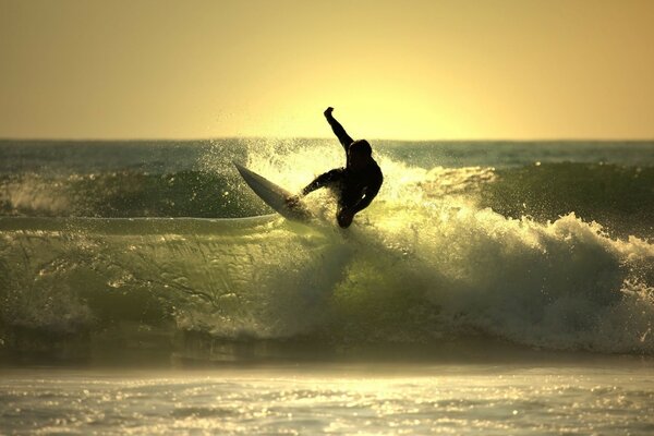 Surfer im unruhigen Meer bei Sonnenuntergang