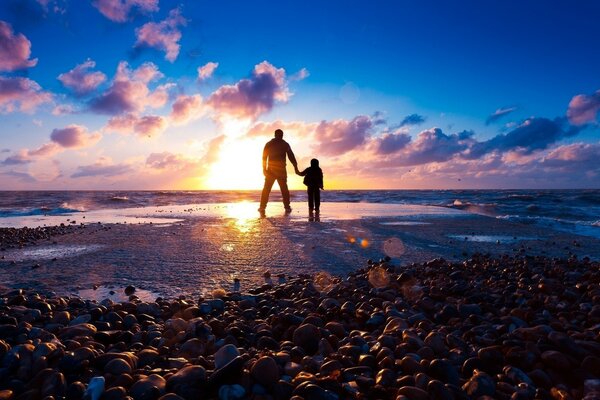 Père et fils admirant le coucher du soleil