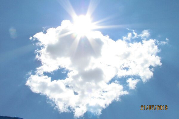 Die Sonne bricht durch eine weiße Wolke