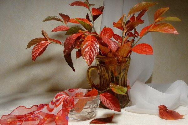 Naturaleza muerta de hojas rojas en un vaso