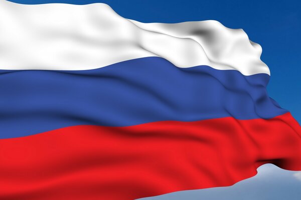 The flag of Russia fluttering in the wind against the blue sky