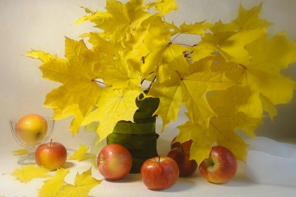 أوراق الخريف مع التفاح على الطاولة