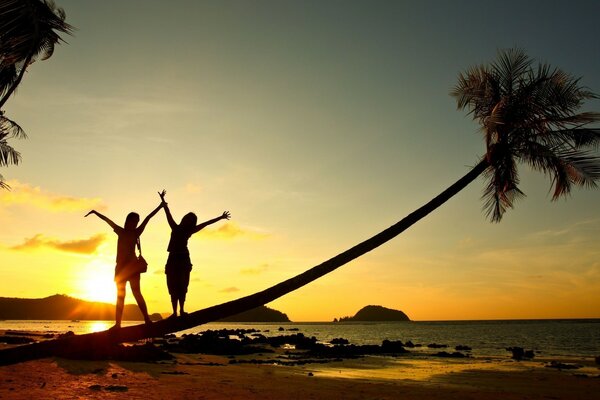 Dos chicas en la playa en medio de la puesta de sol