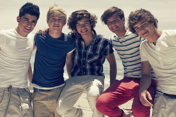 A group of young guys on the beach in sunny weather