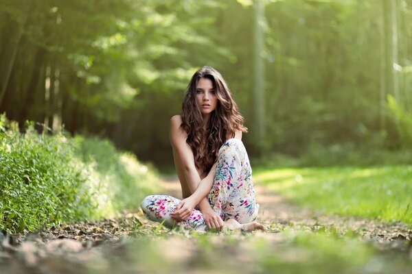 Девушка сидит среди зелени