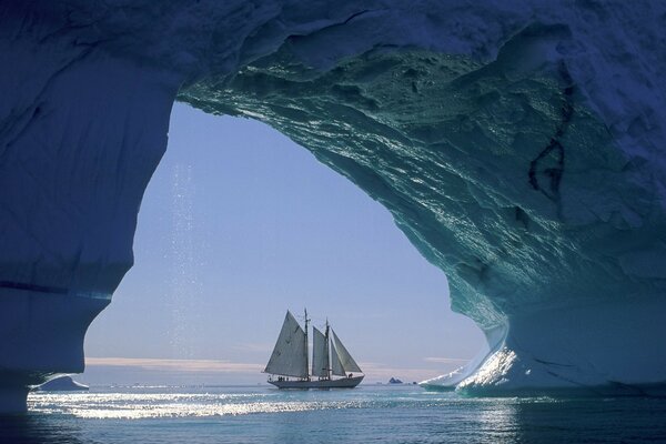 Um veleiro sob um iceberg. Mistérios do oceano