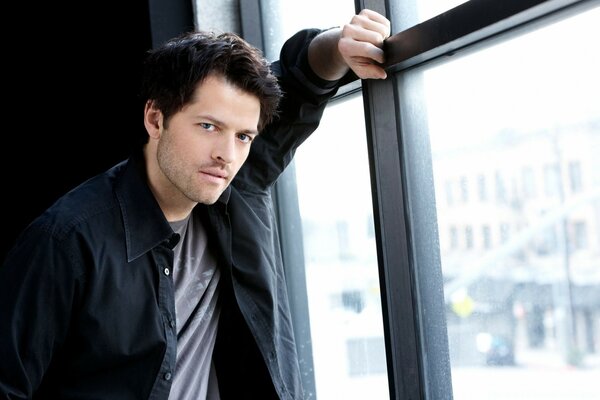 Misha Collins posa perto da janela