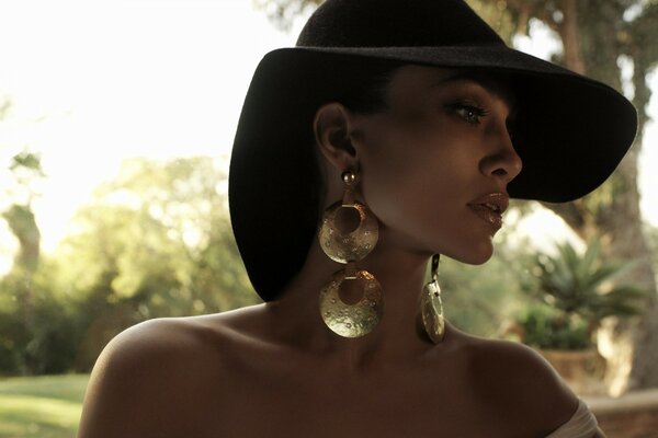 Beautiful mulatto in a hat and earrings