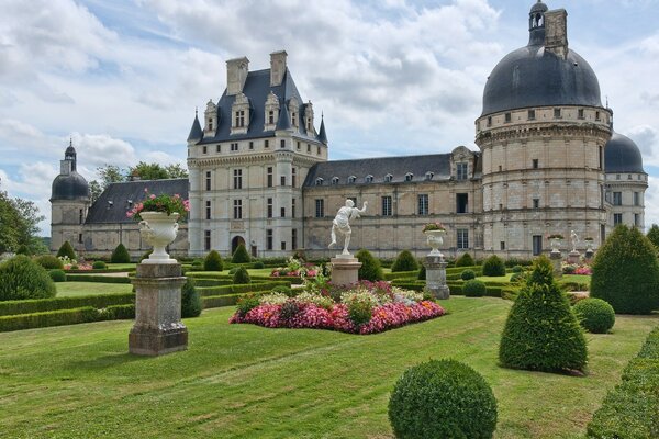 Schloss mit grünem Park und Skulptur