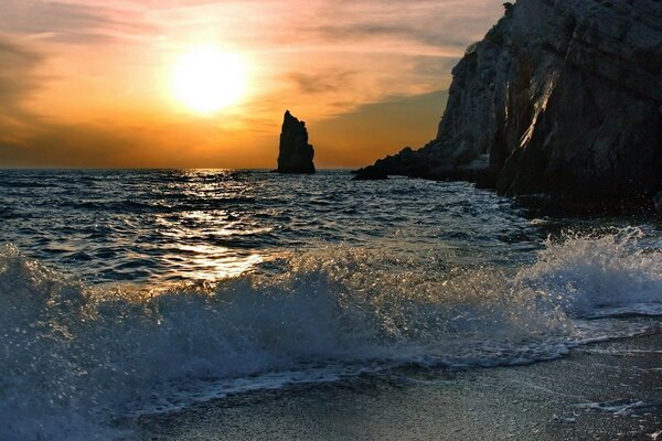 Surf dell oceano sullo sfondo del tramonto