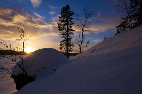 Puesta de sol sobre un enorme campo cubierto de nieve