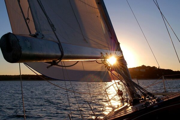 Yacht avec voile sur fond de coucher de soleil