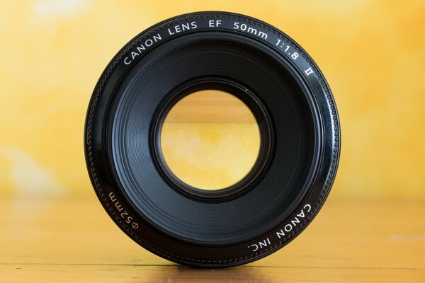 Objectif de la caméra canon sur fond jaune