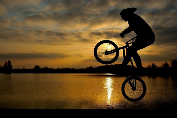 Stunt auf dem Fahrrad vor Sonnenuntergang Hintergrund