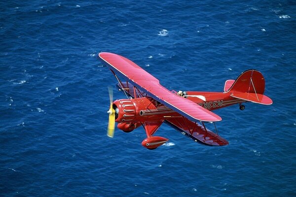 Ein rotes Flugzeug. Blaues Meer