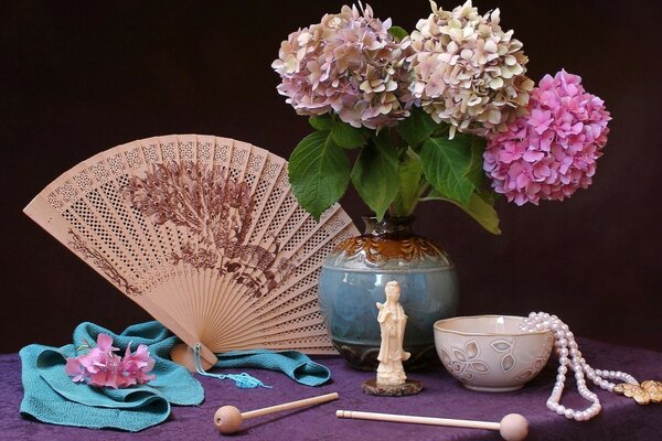 A bouquet of flowers on the table and a fan