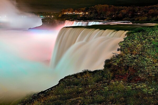 Rainbow waterfall between green trees