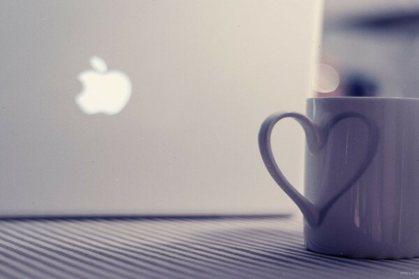 MacBook旁边的马克杯