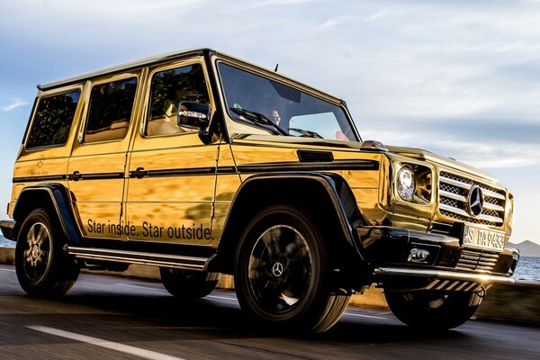 Yellow SUV rides along the seashore