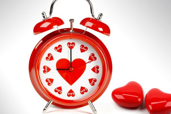 Red alarm clock with hearts on the dial