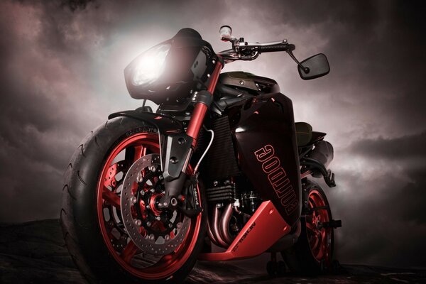 Sportbike rouge sur fond de ciel noir