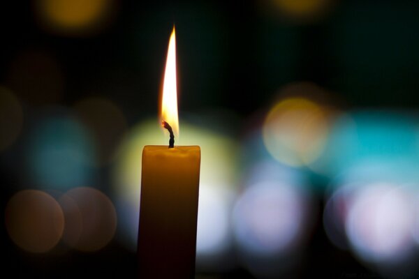 Candle on the background of light glare