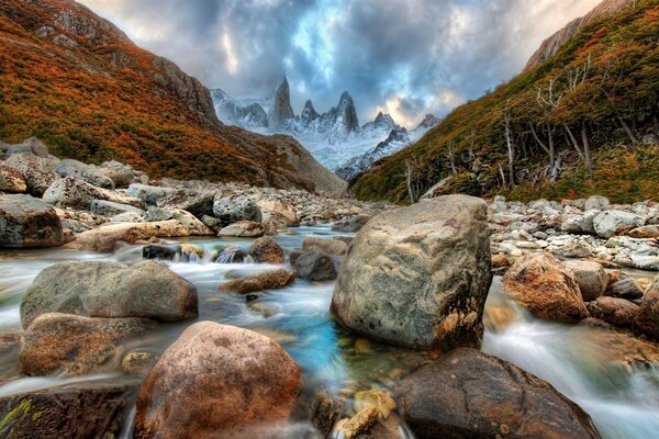 A mountain river runs between large stones