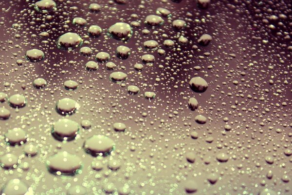 Water droplets on pink glass