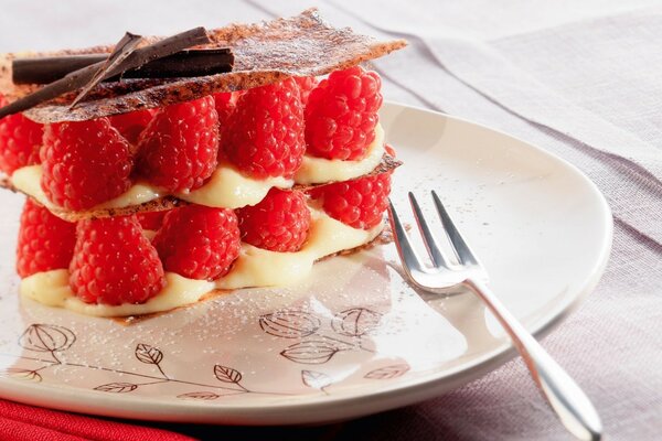 Dessert mit Himbeeren auf einem Teller mit einer Gabel