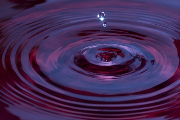 The texture of purple-crimson water. Falling raindrops