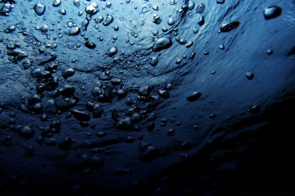 Macro shooting of water with bubbles and drops of blue color