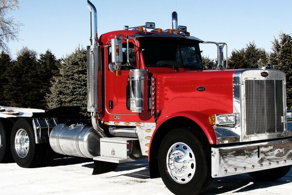 A red truck without a trailer is on the road