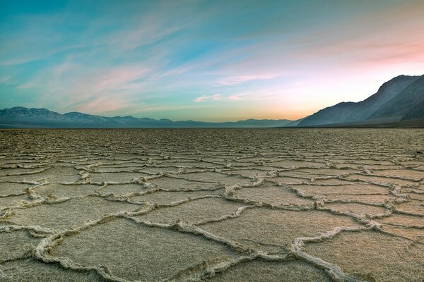 The land left without water for a long time against a pink sky