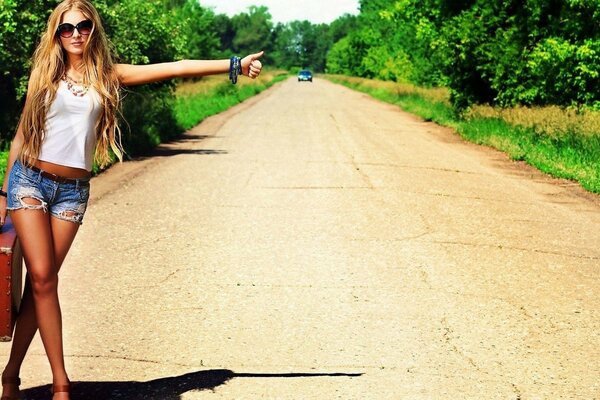 Chica en pantalones cortos en la carretera