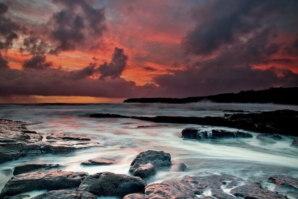 Dusky sunset by the water with rocks