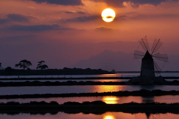 Watermill on the background of the setting sun