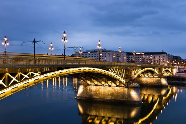 A half-illuminated bridge over a dark river