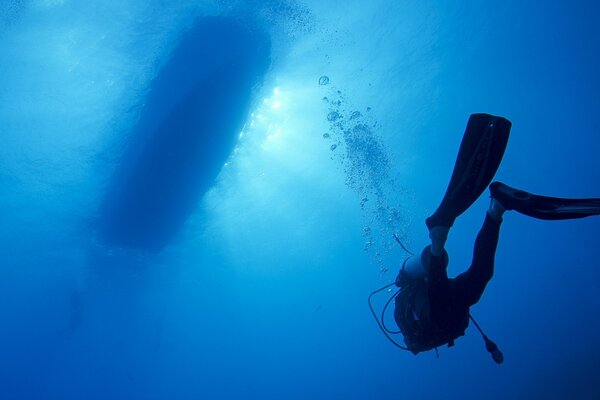 Scuba diver floats from the seabed to the boat