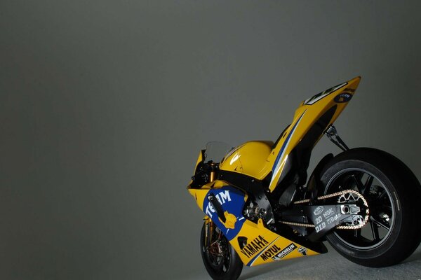 Moto de sport jaune sur fond gris