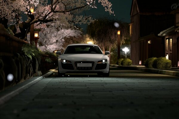 A white car on a night street in spring