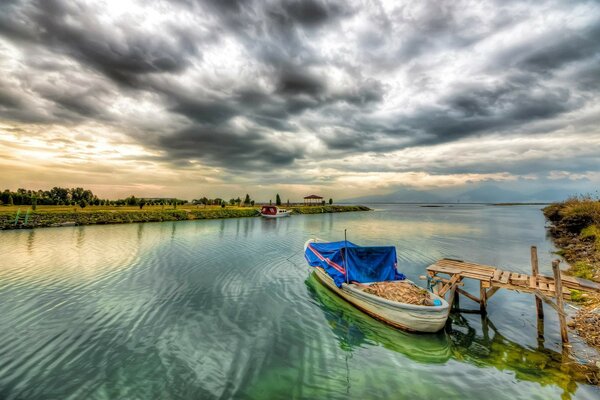 Büyük nehirdeki iskelenin yanındaki tekne