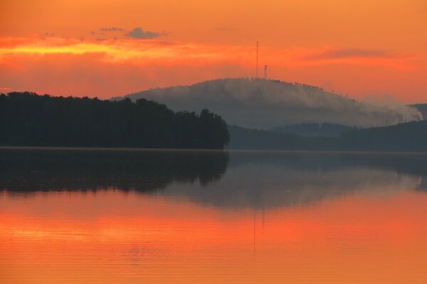 Puesta de sol naranja en el lago en las montañas