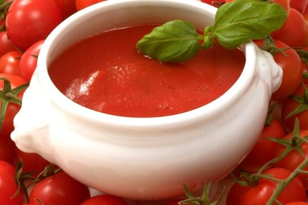 Salsa en un plato sobre tomates rojos