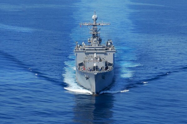 A warship plows the ocean