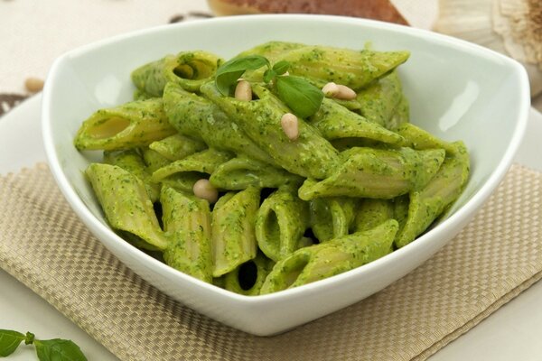 Pasta in green sauce is beautifully served