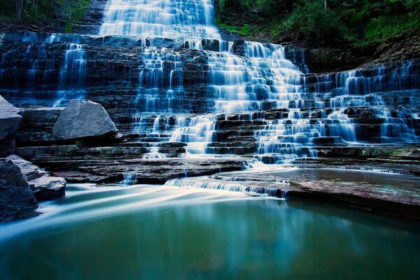 Schöner blauer Wasserfall auf Steinen