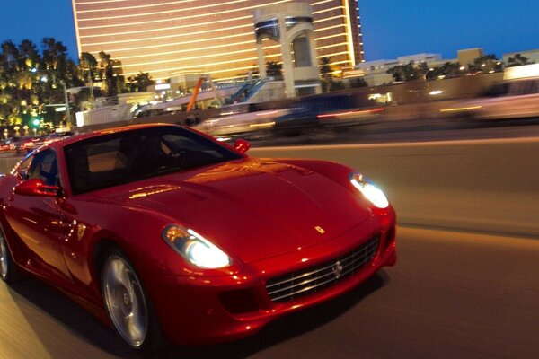 A beautiful brass Ferrari sports car is driving fast on the evening road