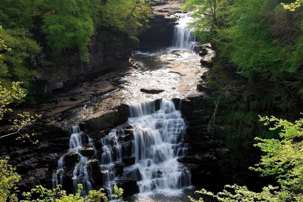 Bella cascata a gradini con pietre e rotoli