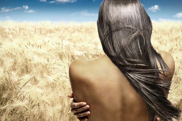 Ragazza nuda sullo sfondo di un campo di grano