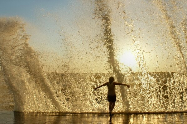 Uomo che corre lungo la spiaggia e vicino a squirt